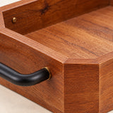 Close view of the wooden serving tray's smooth coffee-brown grain, clipped corner and iron handle.