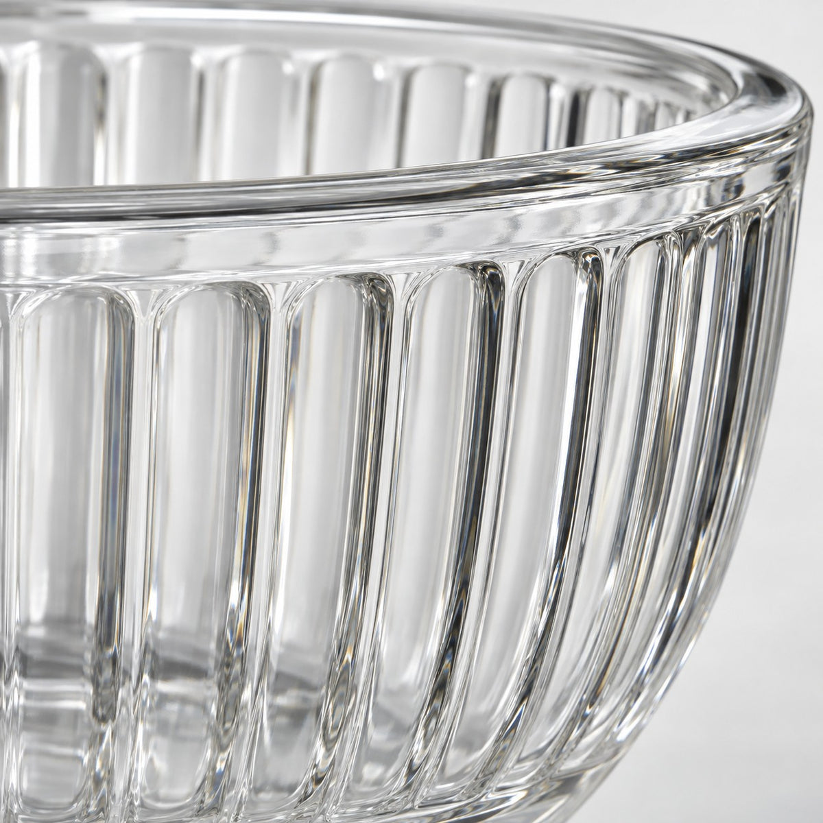 Close-up of the thick clear glass rim and fluted finish on a mixing bowl.