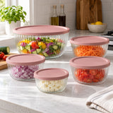 Glass mixing bowls hold separate prepared ingredients on a sunlit kitchen counter.