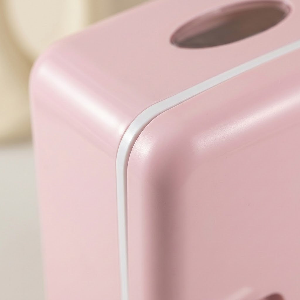 Close-up of a pink plastic dispenser or container with a rounded corner, a white seam line, and a dark oval opening near the top.