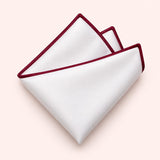 One white polyester pocket square with a burgundy border is folded on a pale blush background.