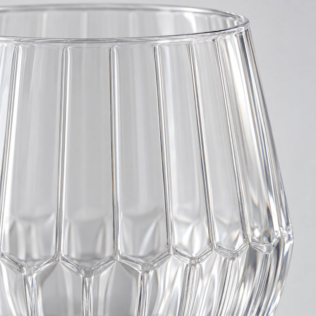 Macro detail shows the clear PET material, vertical ribs and faceted base of the wine glass.
