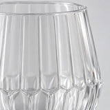 Macro detail shows the clear PET material, vertical ribs and faceted base of the wine glass.