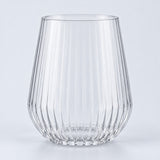 Single clear-rim stemless ribbed plastic wine glass centered on a pale gray backdrop.