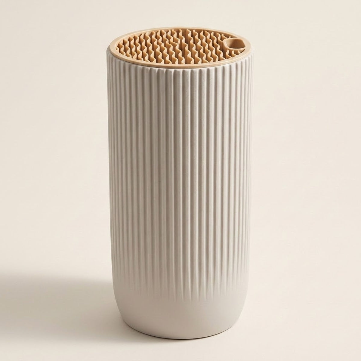 A ribbed ceramic tumbler in a warm off-white color with a natural light wood lid, photographed on a solid light beige background.