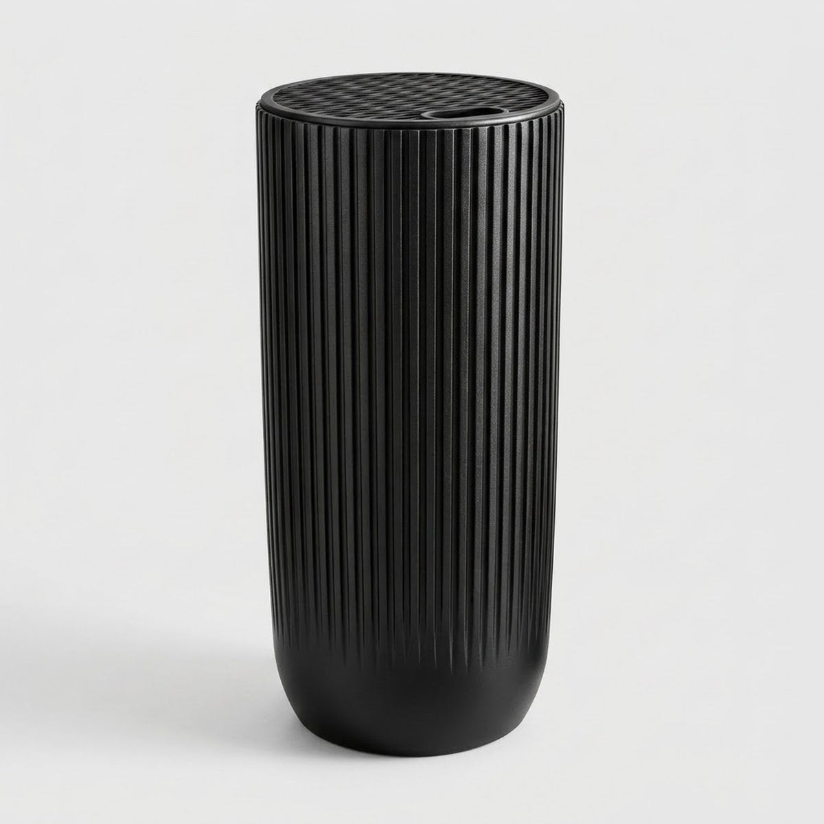 A black cylindrical container with a vertically ribbed fluted texture and a matching ribbed lid, shown on a clean light gray background.