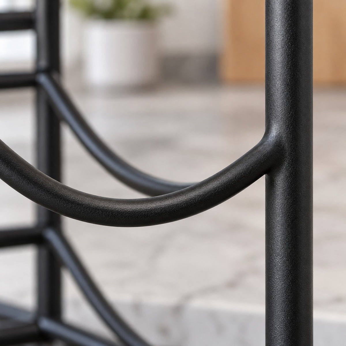 Close-up of the black iron organizer shows its smooth coated finish and curved bottle cradle.