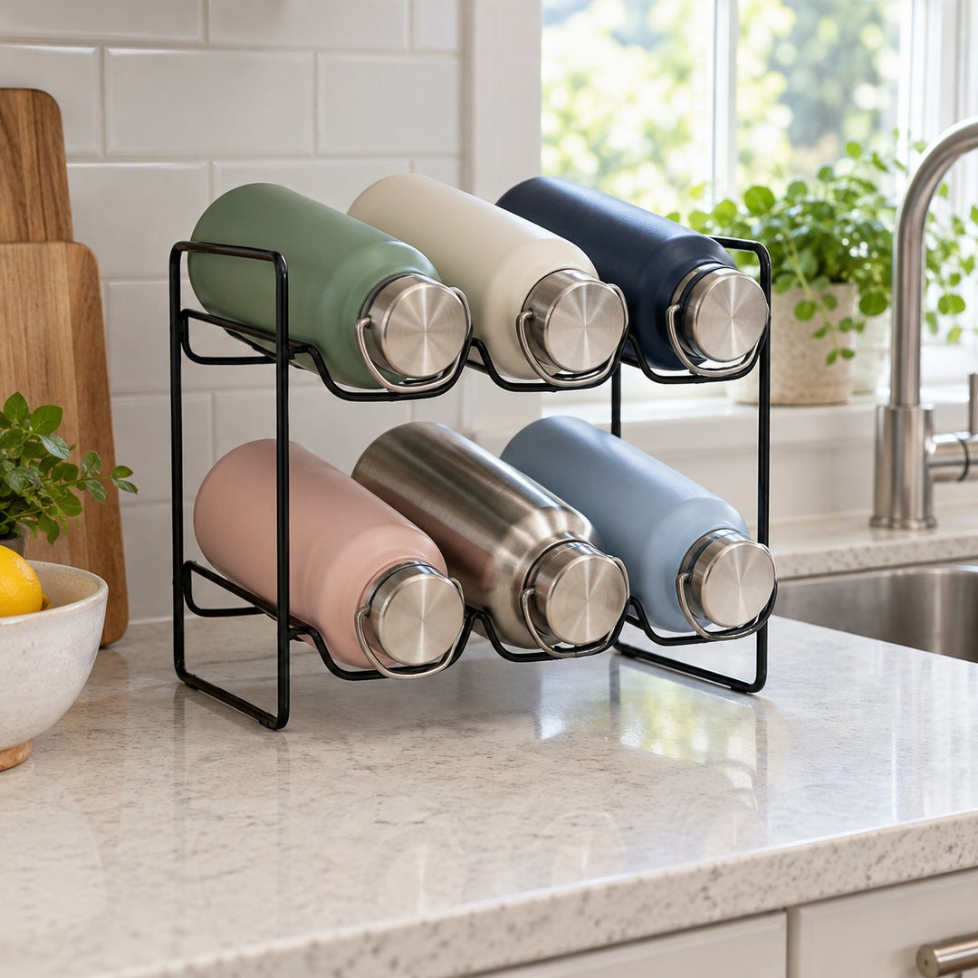 Black two-tier water bottle organizer gathers reusable bottles neatly on a bright kitchen counter.