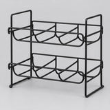 Black two-tier water bottle organizer stands alone against a pale gray studio background.