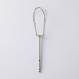 A stainless steel kitchen utensil with a long straight handle and a looped head, shown vertically against a light gray background.