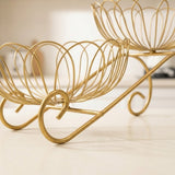 Gold metal wire bowl stand with two flower-shaped wire baskets on a curved base, photographed on a light neutral surface.