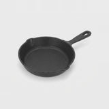 A classic black cast iron skillet with a single loop handle, shown from a high-angle perspective on a light gray background.
