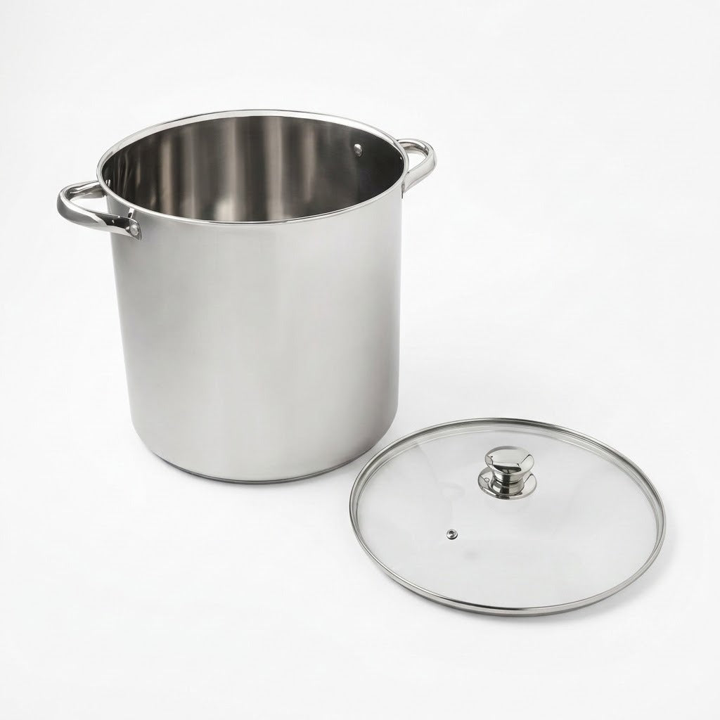 A stainless steel stockpot with side handles next to its clear glass lid with a metal rim and knob, photographed on a clean white background.