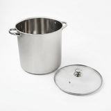 A stainless steel stockpot with side handles next to its clear glass lid with a metal rim and knob, photographed on a clean white background.