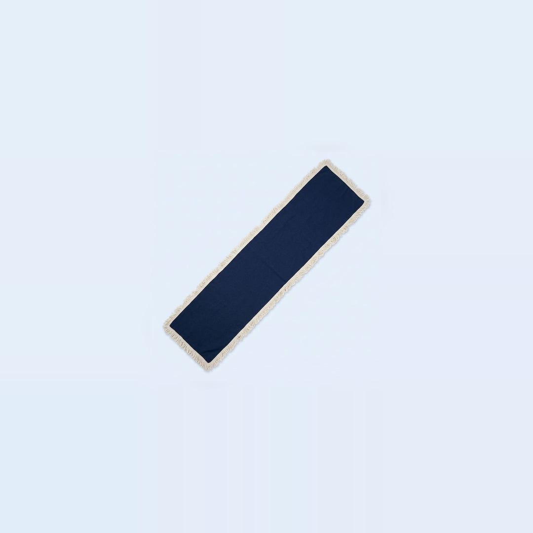 A long, narrow rectangular navy blue fabric accessory with a light beige or cream border, shown diagonally on a very pale blue background.
