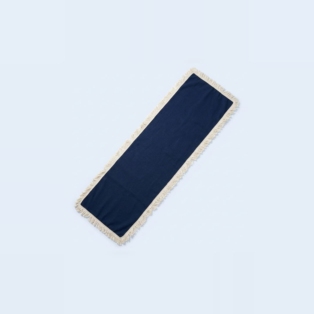 A long rectangular navy blue runner with cream fringe on both ends, displayed diagonally on a light blue background.