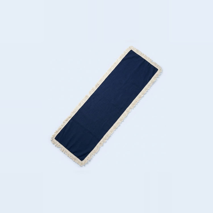 A long rectangular navy blue runner with cream fringe on both ends, displayed diagonally on a light blue background.