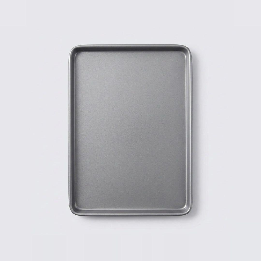 A rectangular metal baking sheet with raised edges, shown from a top-down view on a light gray background.