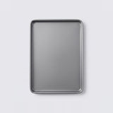 A rectangular metal baking sheet with raised edges, shown from a top-down view on a light gray background.