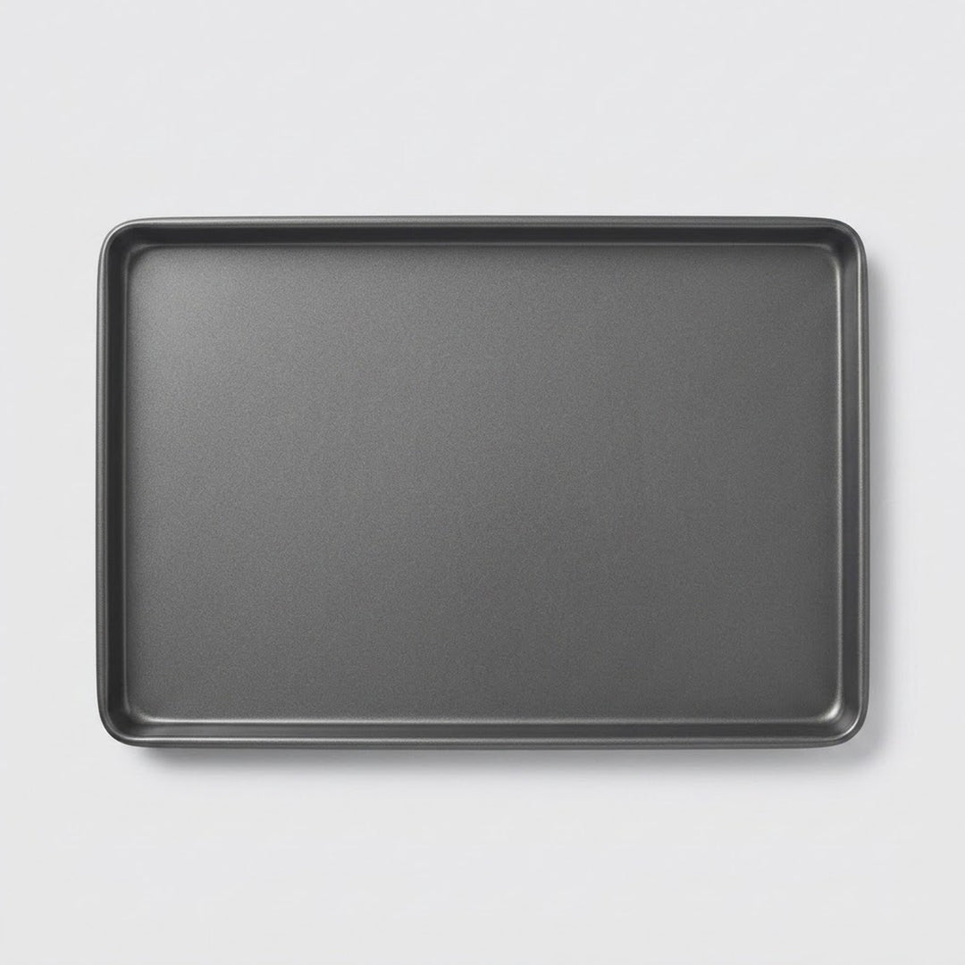 A dark gray rectangular baking pan with raised rounded corners, shown from a top-down perspective on a light gray background.