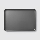 A dark gray rectangular baking pan with raised rounded corners, shown from a top-down perspective on a light gray background.