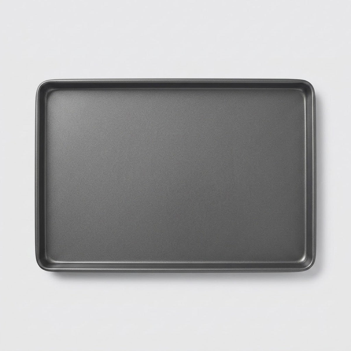 A dark gray rectangular baking pan with raised rounded corners, shown from a top-down perspective on a light gray background.