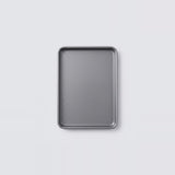 A rectangular metal baking pan with raised edges, shown from above on a light gray background.