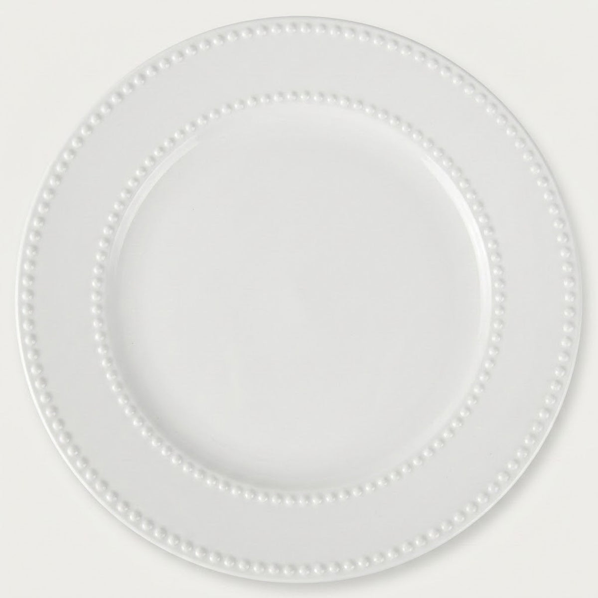 A white ceramic plate with a decorative beaded border, shown from a top-down view on a light off-white background.