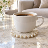 White Pearl Beaded Coaster under a coffee cup on a marble table protects the surface.