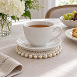 White Pearl Beaded Coaster beneath a teacup and plate on a dining table.