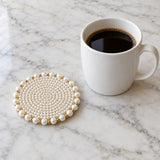 White Pearl Beaded Coaster beside a ceramic mug shows its compact size.
