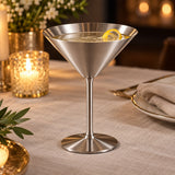 Silver Stainless Steel Martini Cup presents a champagne cocktail on a softly lit dinner table.