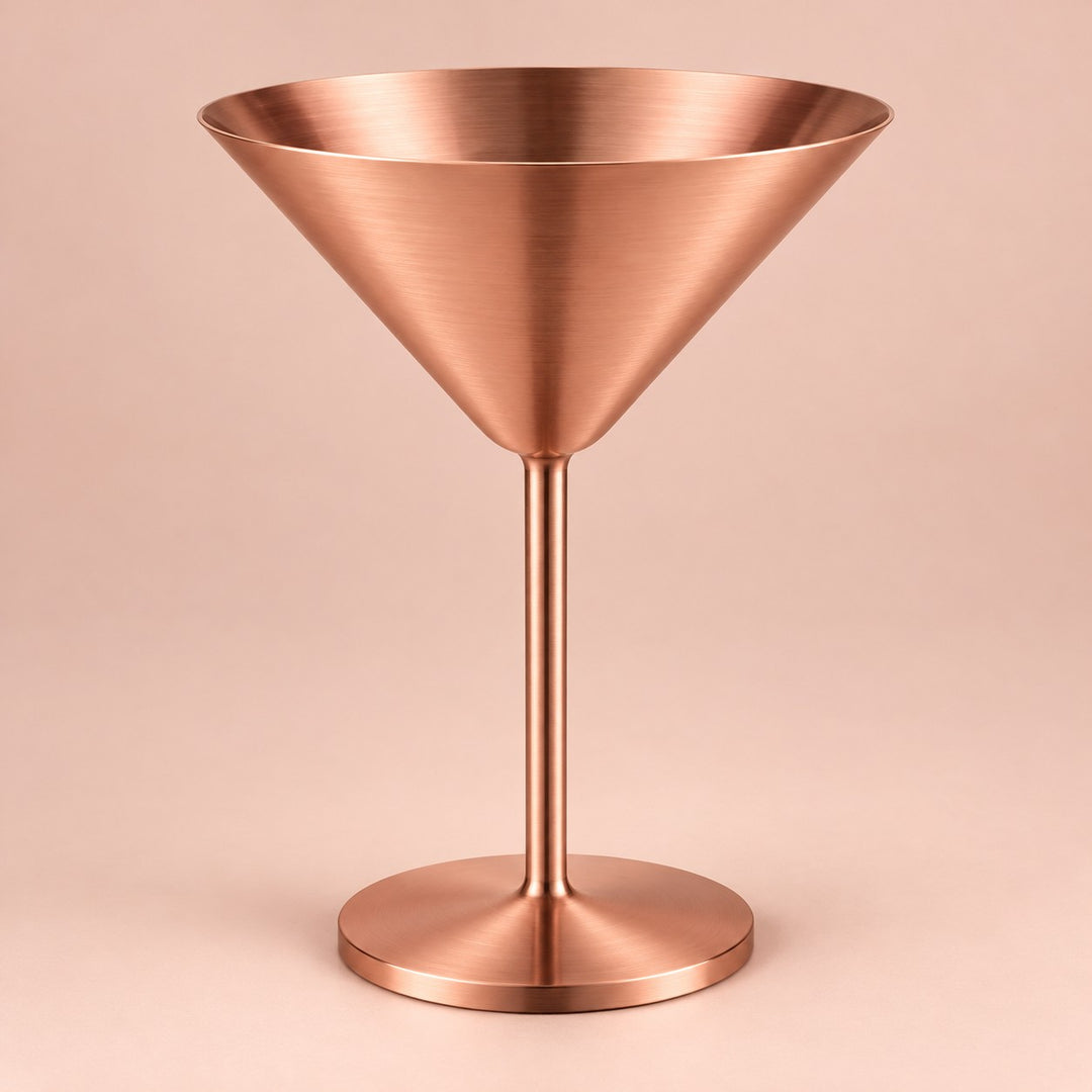 Copper Stainless Steel Martini Cup stands centered against a pale copper blush studio backdrop.