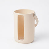 A minimalist beige silicone mug with a large vertical cutout and a matching handle, shown on a clean white background.