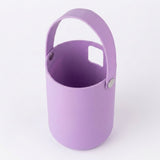 A light purple silicone bucket with a matching handle and a small square cutout on the side, shown on a clean white background.