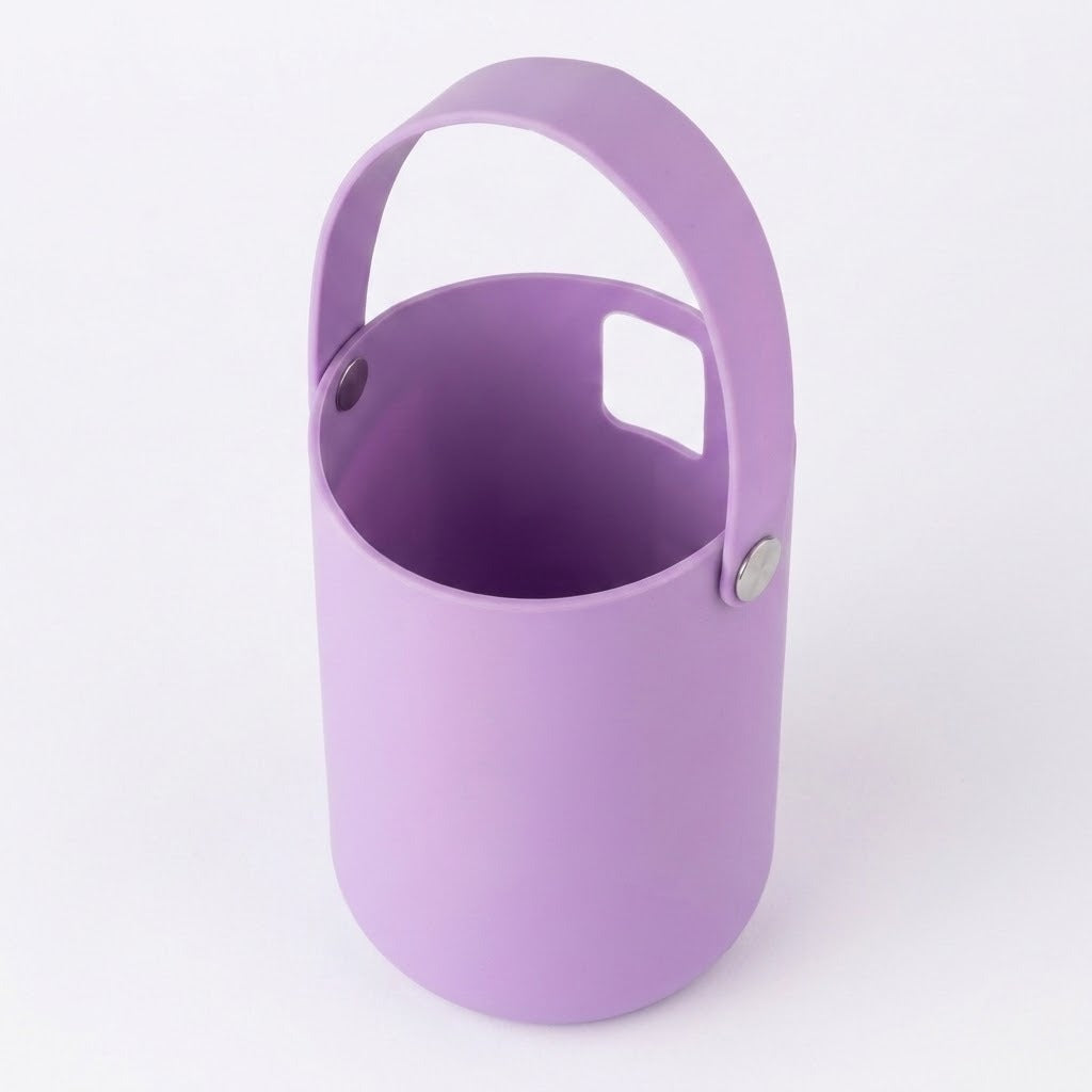 A light purple silicone bucket with a matching handle and a small square cutout on the side, shown on a clean white background.