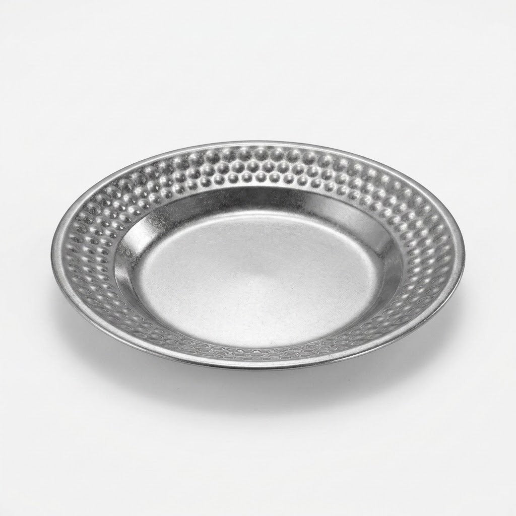 A round silver metal plate with a textured, dimpled border and a smooth, slightly beveled center, shown on a light gray background.