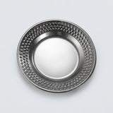 A round metallic silver plate with a textured, dimpled pattern around the rim, shown from a top-down perspective on a light gray background.