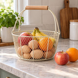 Beige Wire Basket with Wood Handle holds eggs and fruit beside an apple and orange for scale.