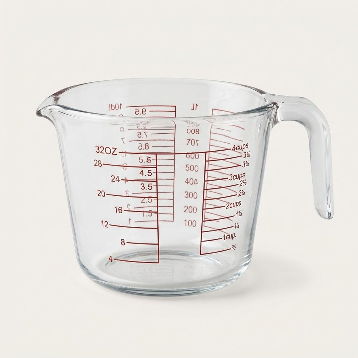 Clear glass measuring cup with red measurement markings and a curved handle, photographed on a plain light background.