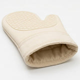 A single cream-colored fabric oven mitt with a textured diamond-patterned non-slip grip on the palm side, shown on a clean white background.