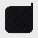 A black quilted pot holder with a diamond pattern and a small loop at the top right, shown on a light gray background.