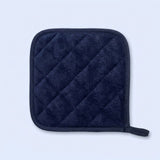 A dark navy blue quilted pot holder with a small loop on the bottom right, shown on a light blue background.