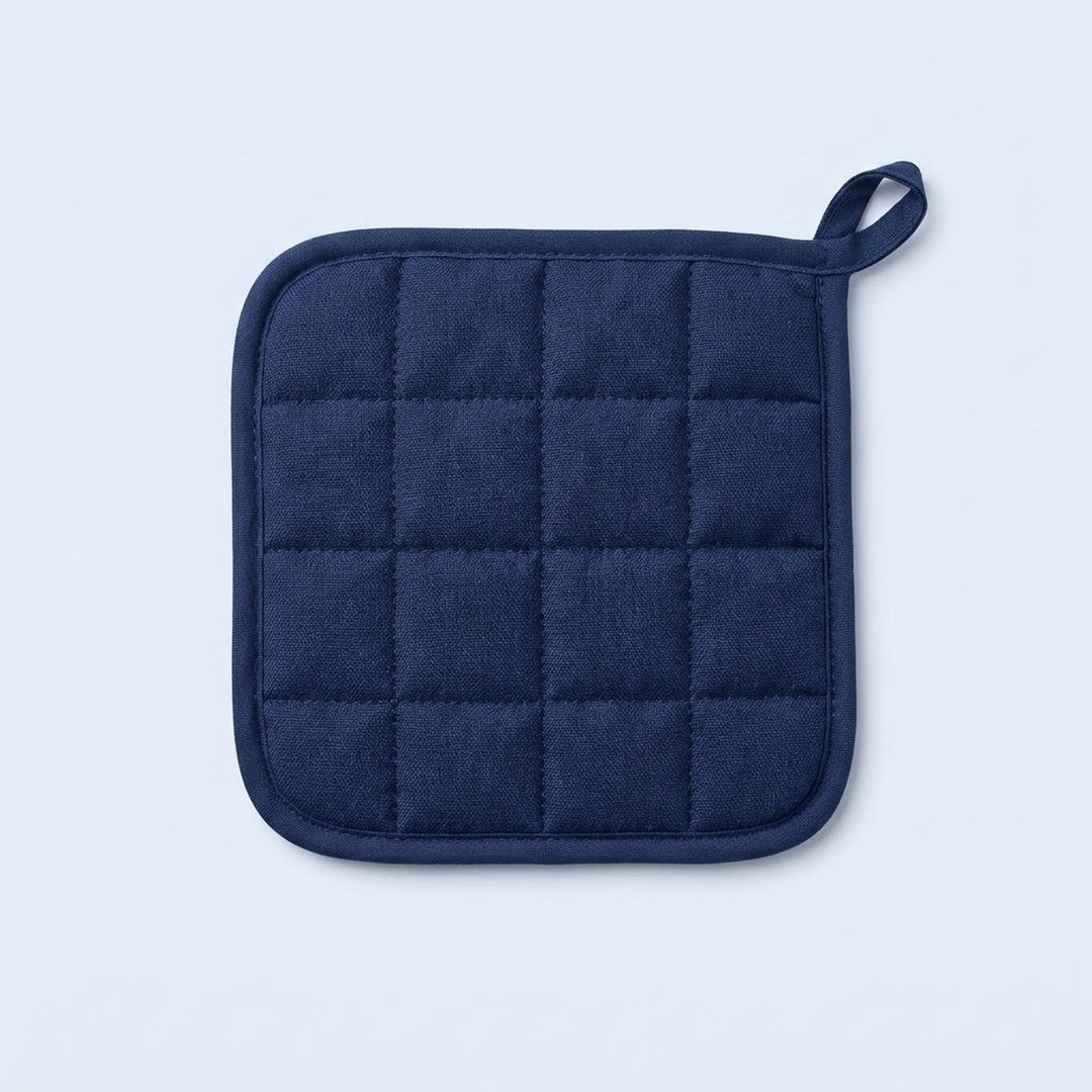 A navy blue quilted pot holder with a small loop handle, shown flat against a light blue background.