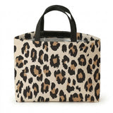 A rectangular tote bag with a beige, brown, and black leopard print pattern and black shoulder straps, shown on a plain white background.