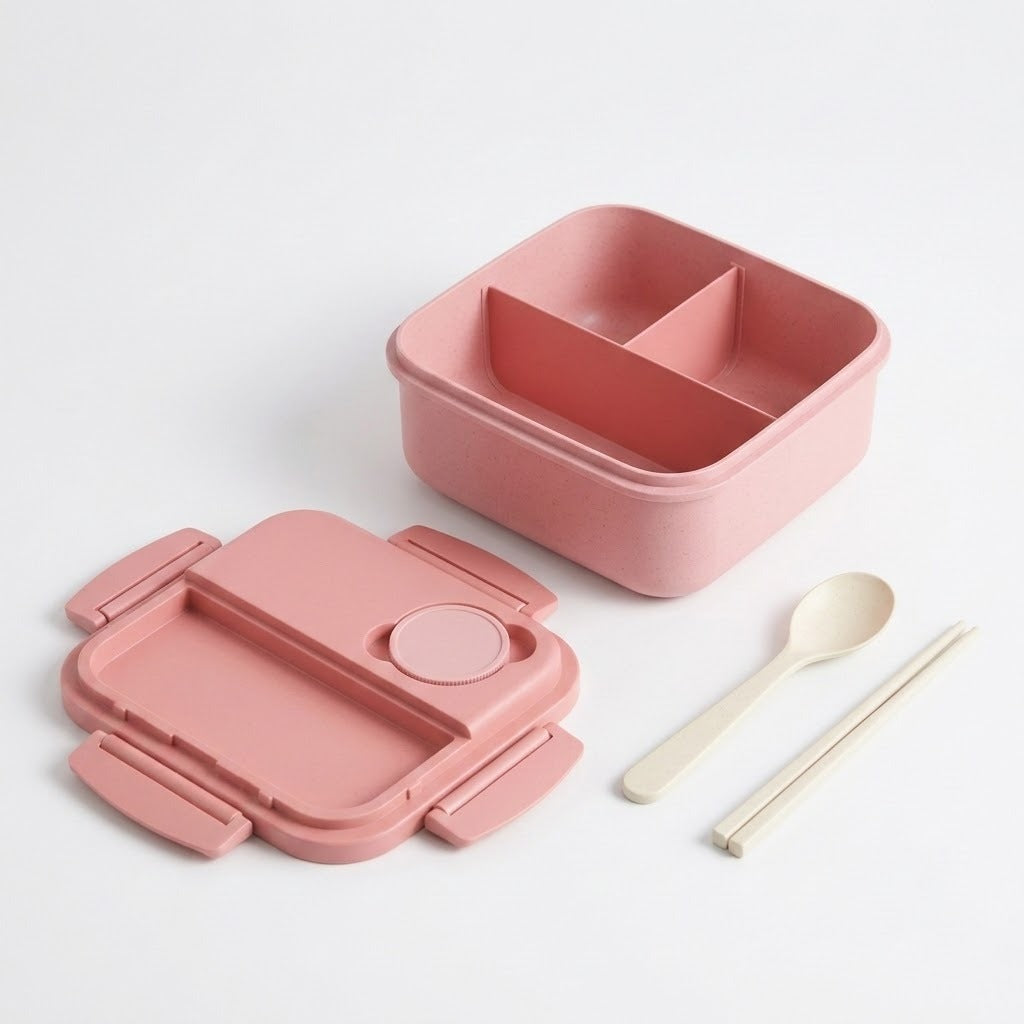 A pink compartment lunch box set on a clean white background, including the main divided lunch box, the open lid with a small circular insert, a spoon, and chopsticks.