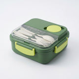 A green lunch box with a clear lid, lime green accents, and white utensils inside, photographed on a clean white background.