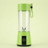 A portable electric blender with a bright lime green base and lid, a clear cylindrical container, a small silver blade, and a matching green carrying loop, shown on a pale yellow-green background.