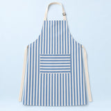 Blue striped kitchen apron with a horizontal pocket and adjustable straps on a pale blue studio backdrop.