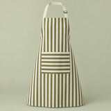 Green striped kitchen apron with a horizontal pocket and adjustable straps on a pale green studio backdrop.